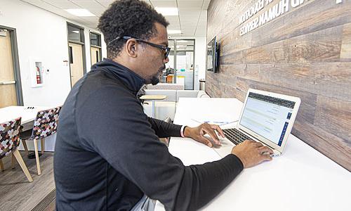 一个学生在用笔记本电脑工作