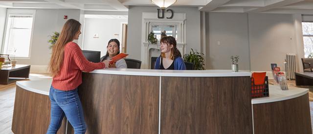 Students working at the front desk in Voorhees